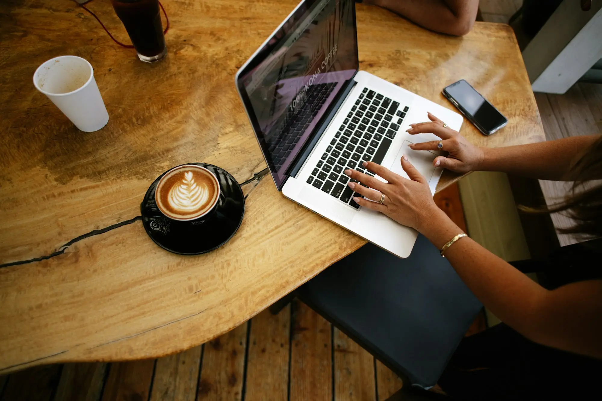 Business owner forecasting cash flow on a laptop in a cafe