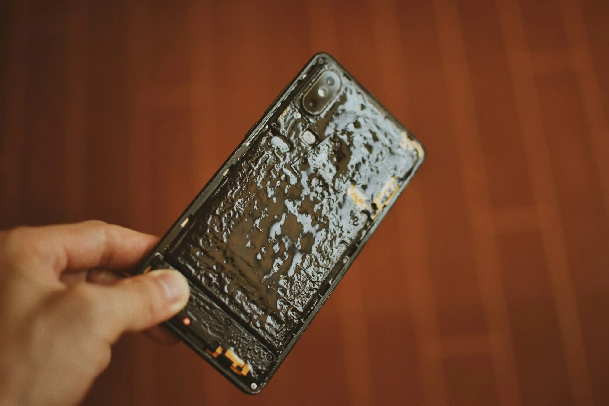 Phone covered in water damage held up for a photo