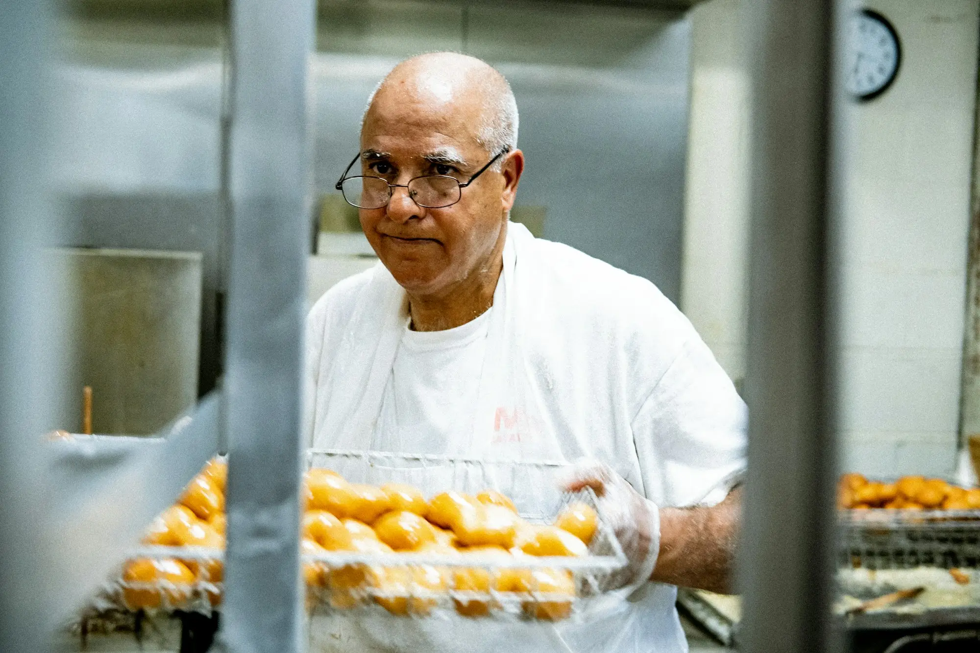 Baker preparing trays of bread as the bakery reopens